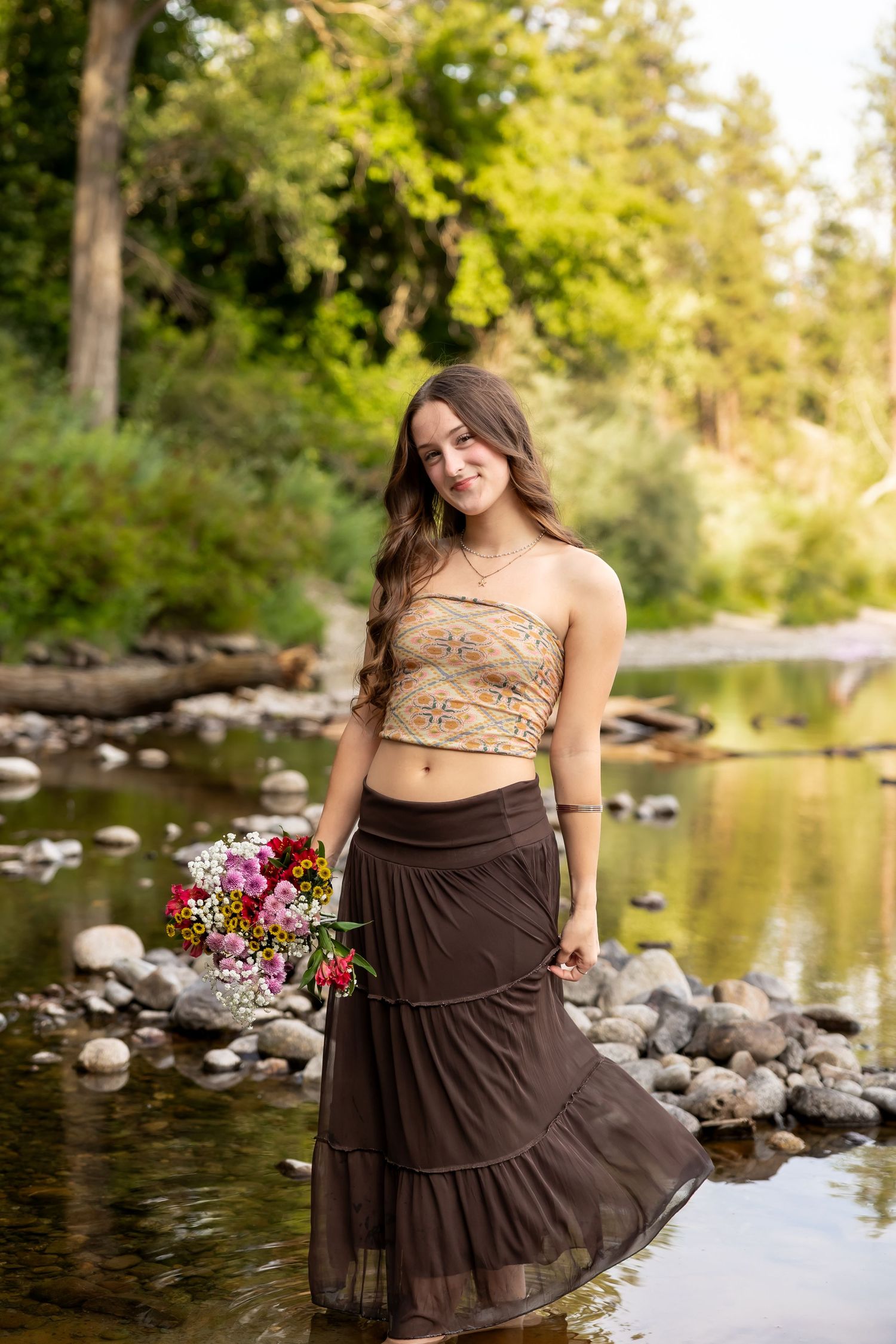 A series of photos showing someone in a brown skirt posing by a rocky stream with sunlit trees in the background.