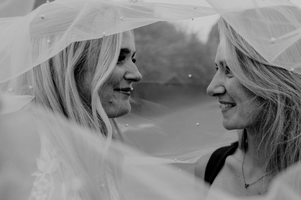 Black and white series of romantic wedding couple portraits through flowing veil.