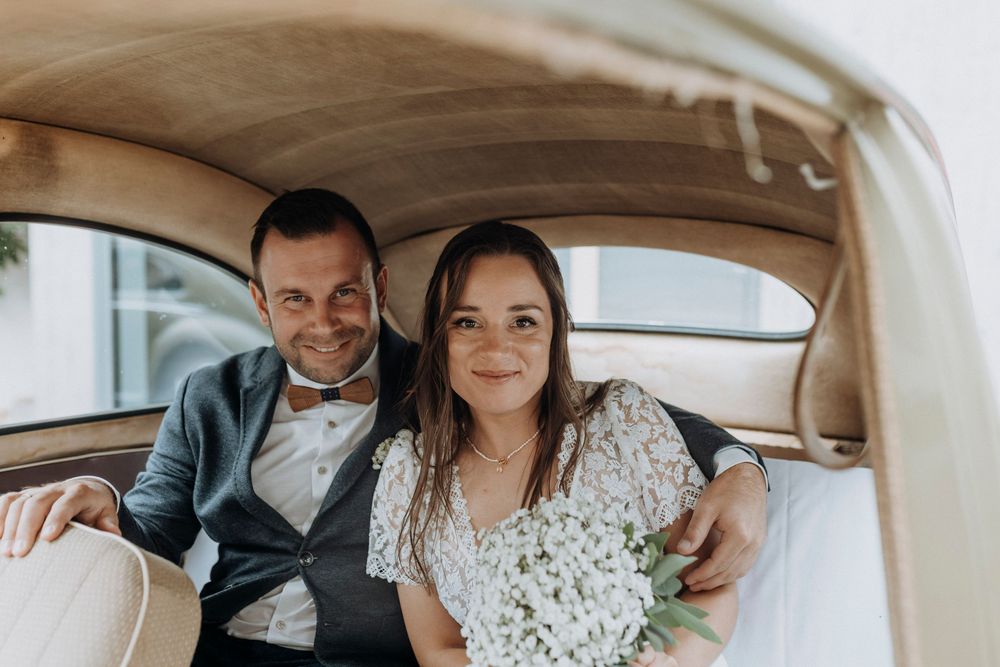 Couple shares tender moments inside a classic car during wedding photoshoot.