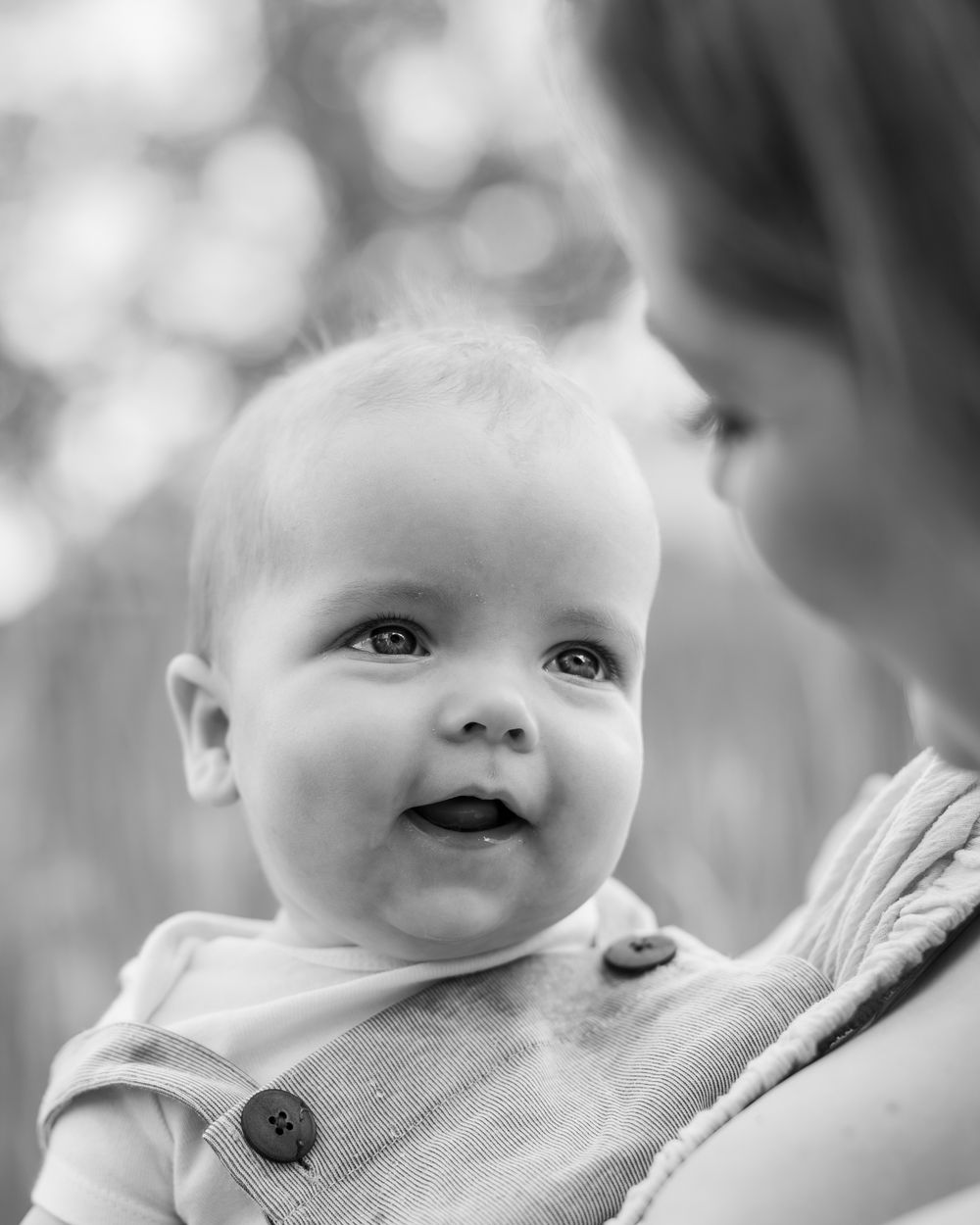 Black and white close-up portrait series showing a baby's sweet expressions and curious eyes.