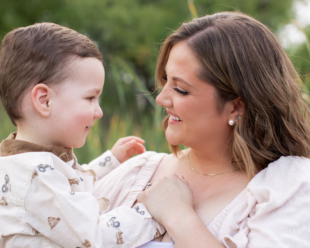 Candid moments between family members in matching pink and white outfits against a natural backdrop.