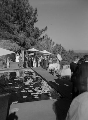 A series of black and white panoramic photos showing an outdoor gathering with trees and structures in the background.