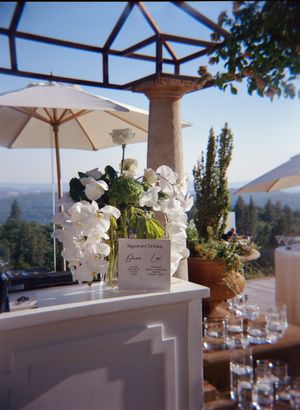 Elegant outdoor wedding reception setup with white umbrellas and orchid centerpieces against a mountain backdrop.

Auberge du Soleil Wedding