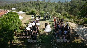 Outdoor wedding ceremony setup with mountain views and rows of white chairs.