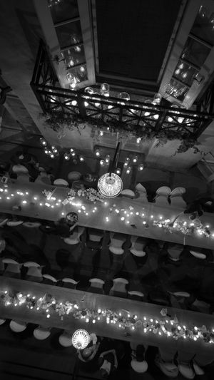 Overhead view of an elegant wedding reception setup with string lights and crystal chandeliers.