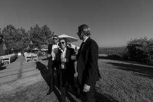Black and white photo series showing people walking along a scenic hilltop path with views of the landscape below.