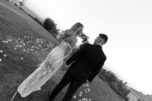 Artistic black and white wedding portraits showing couple in various romantic poses on grassy field.