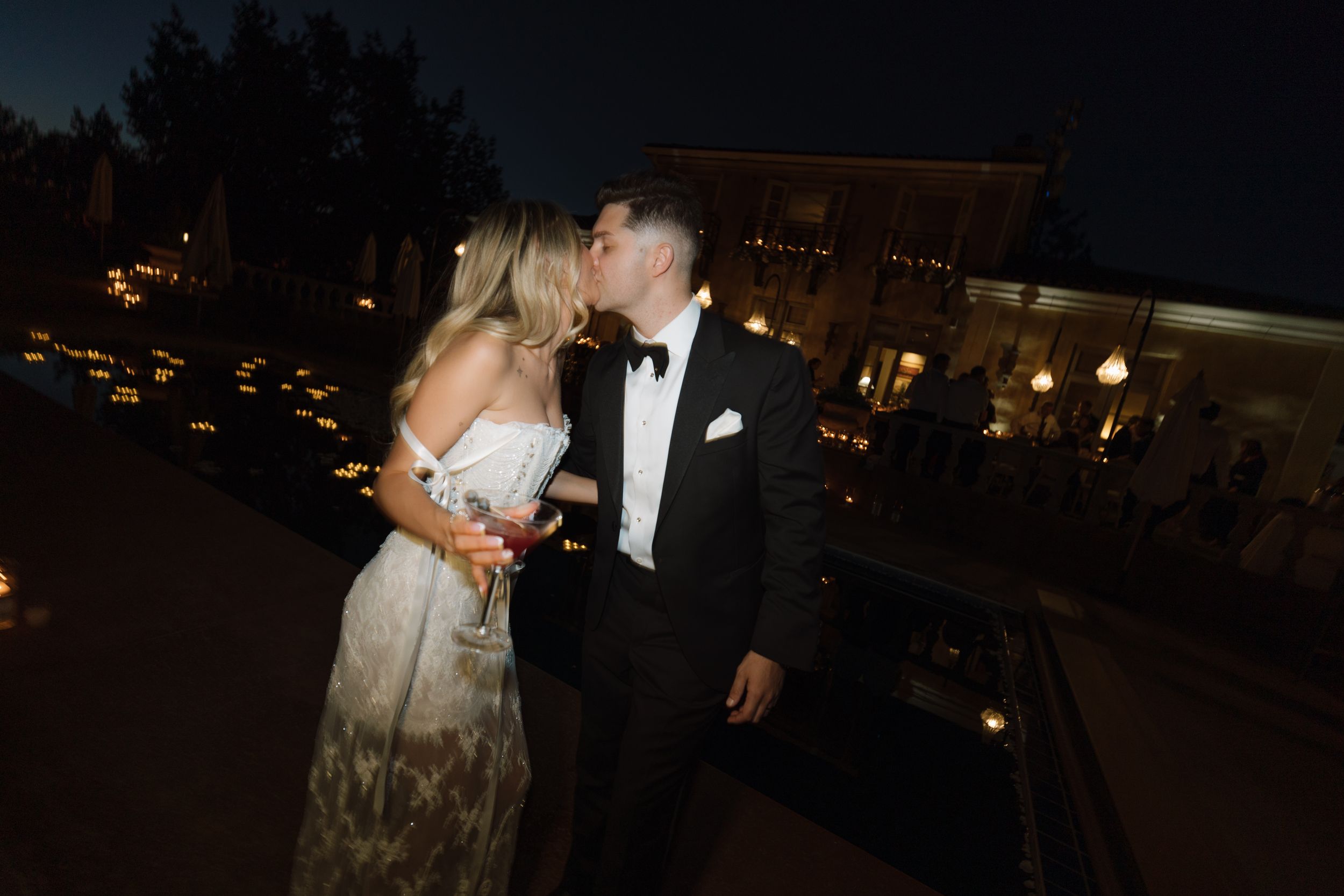 Evening wedding reception with couples dancing under romantic lighting.