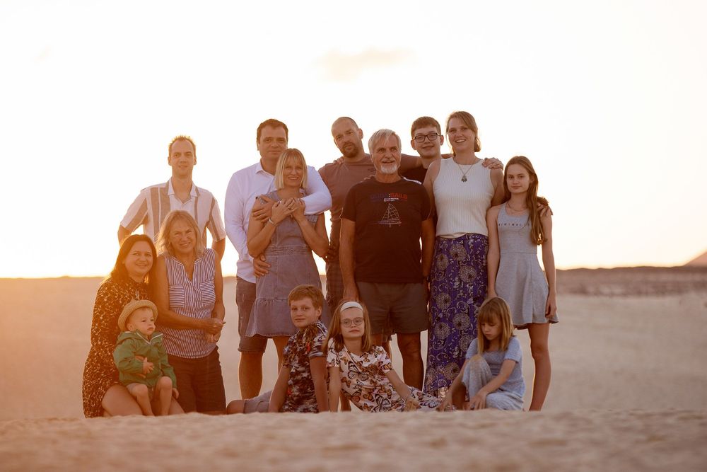 A large multi-generational family gathering on the beach at sunset - Big family photoshoot in Fuerteventura by photoFuerte