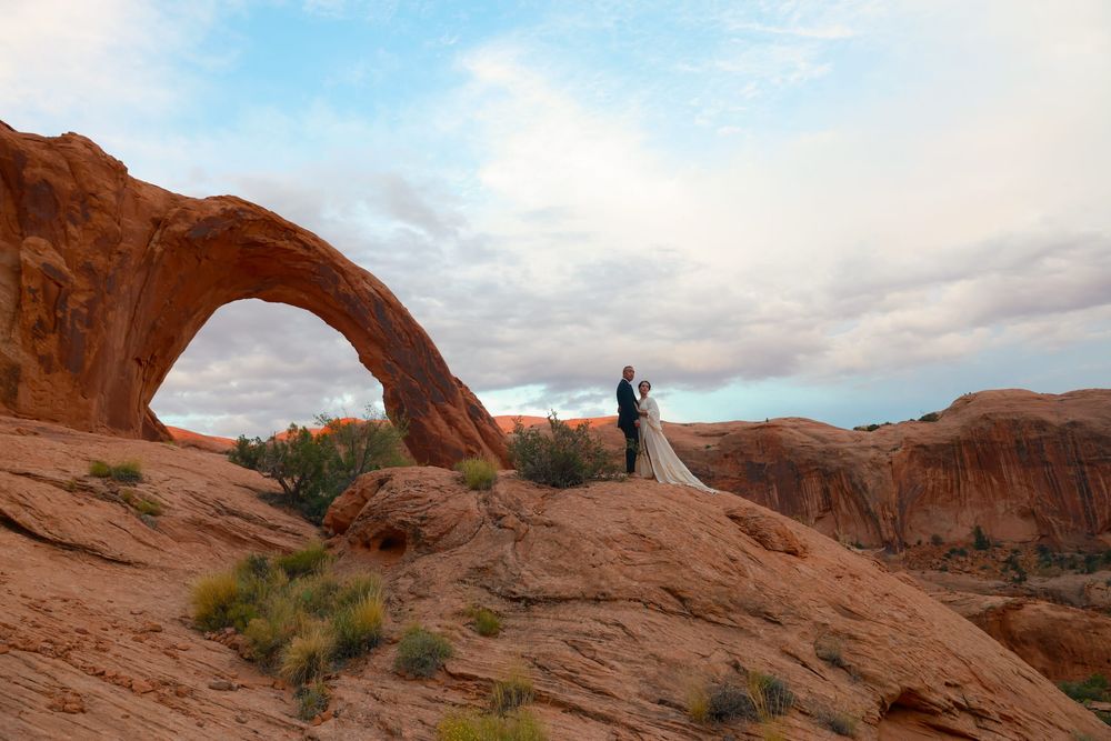 Scenic panorama of red sandstone arches and desert landscape at Arches National Park in Utah during sunset.