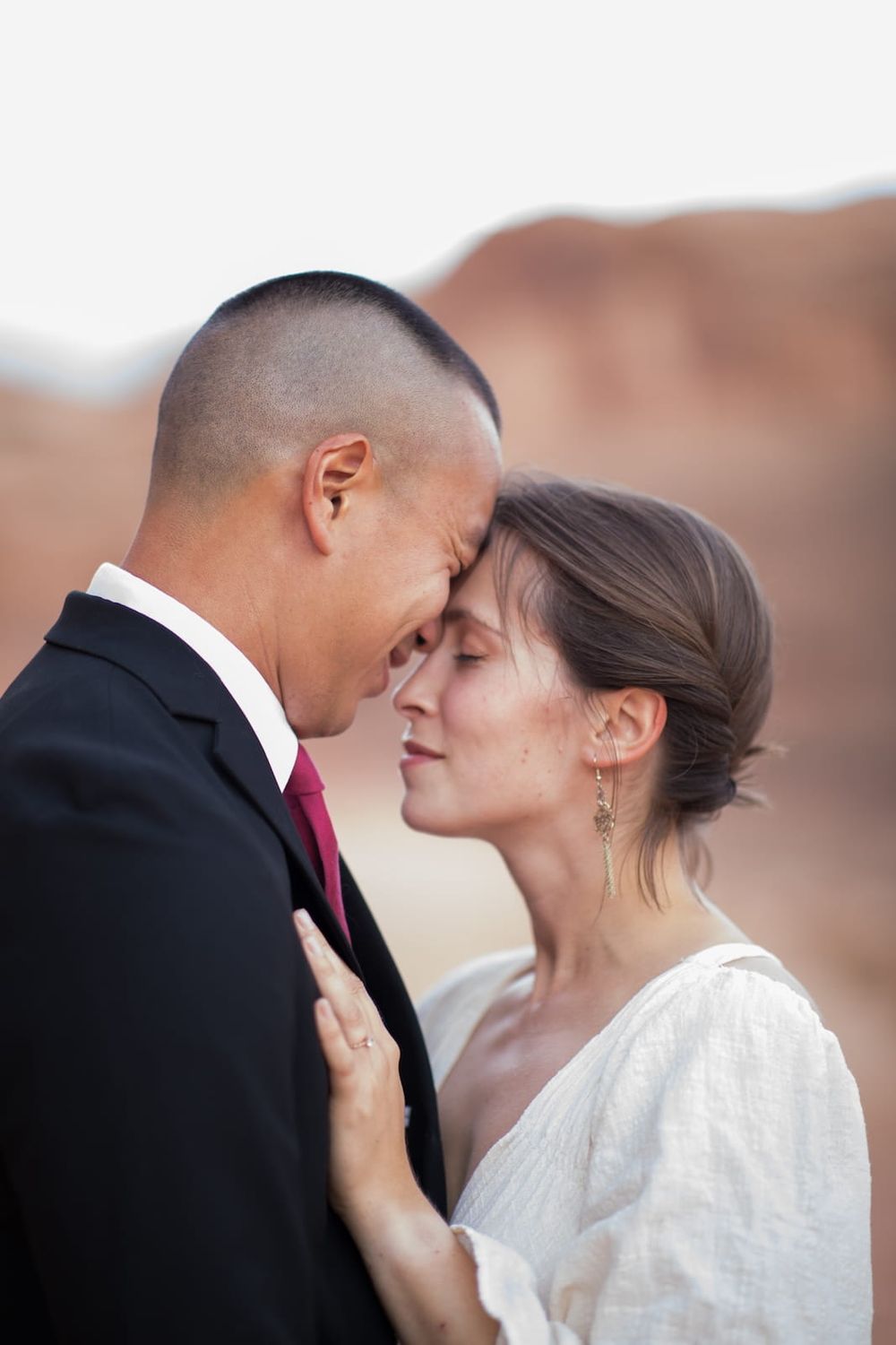 A romantic wedding photo series shows a couple in traditional attire sharing intimate moments against a blurred background.