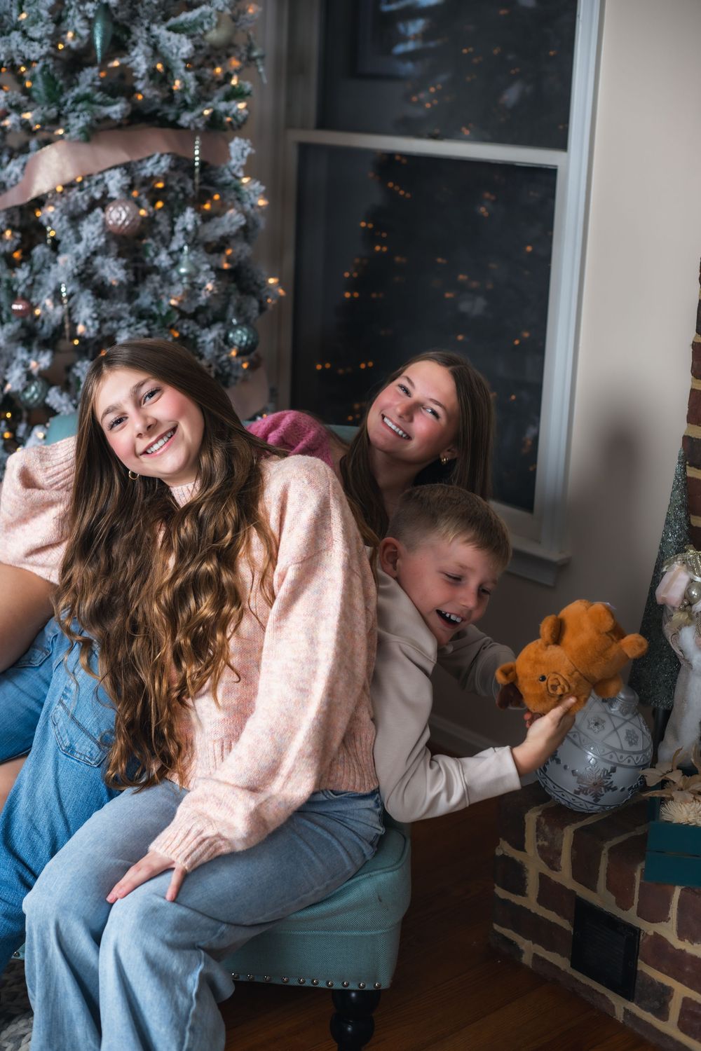 Candid family moment with laughter and joy while sitting on blue couch near Christmas decorations.