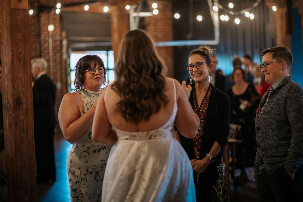 Wedding reception venue decorated with string lights and exposed brick walls creates a warm, rustic atmosphere.