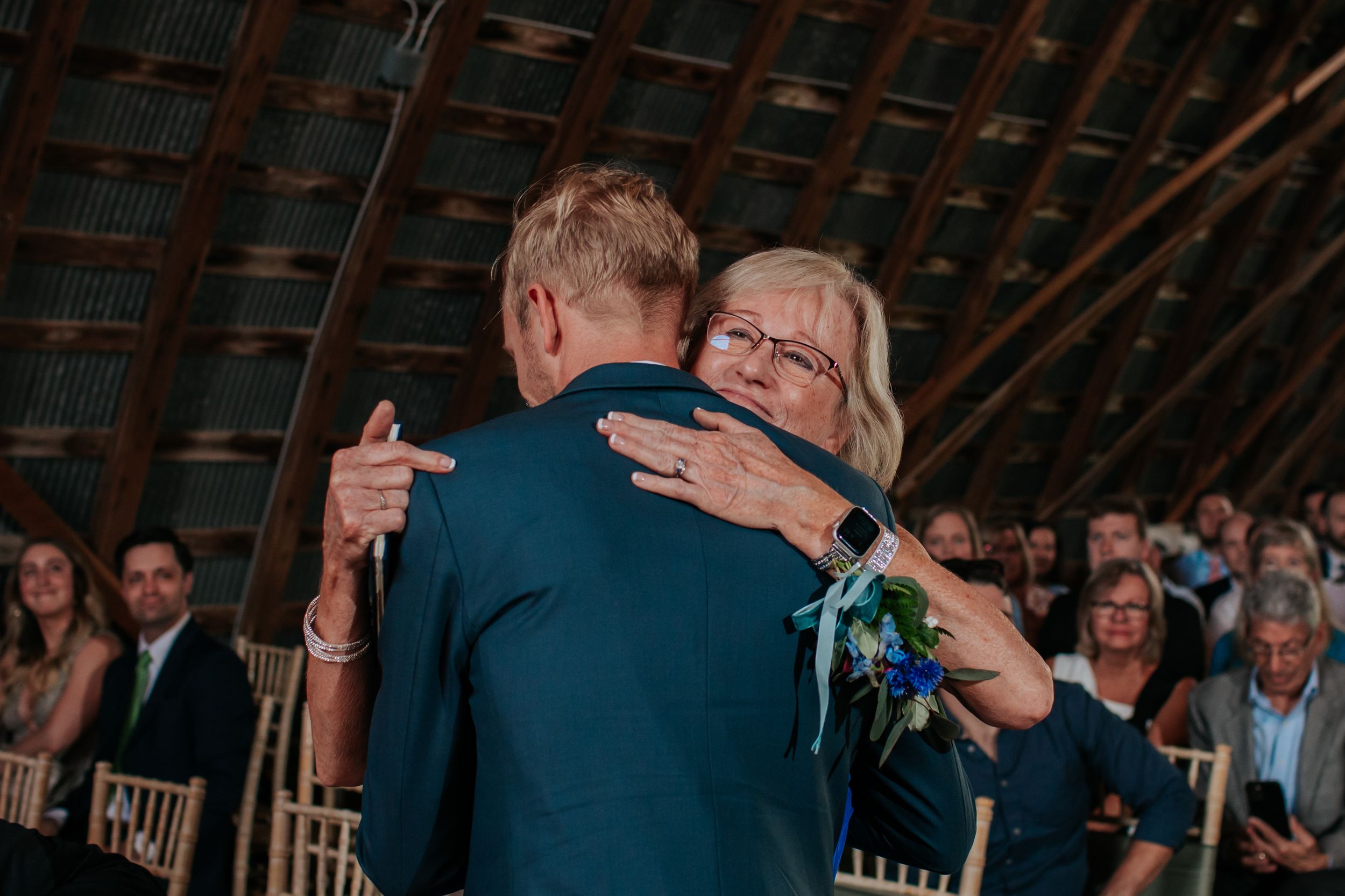 Wedding reception moments captured inside a beautifully lit rustic barn venue.