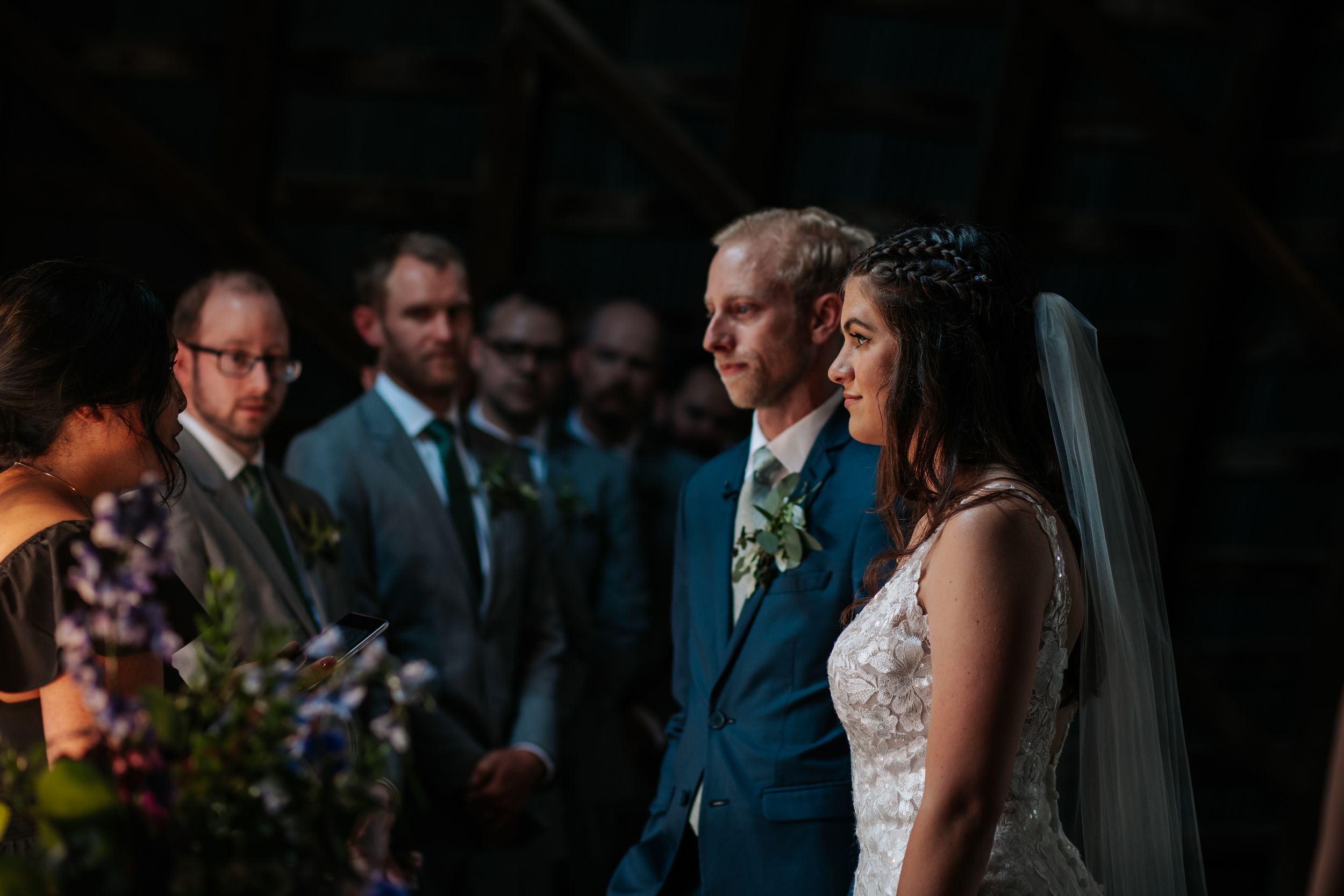 Wedding party members standing in a row wearing navy suits and formal attire.