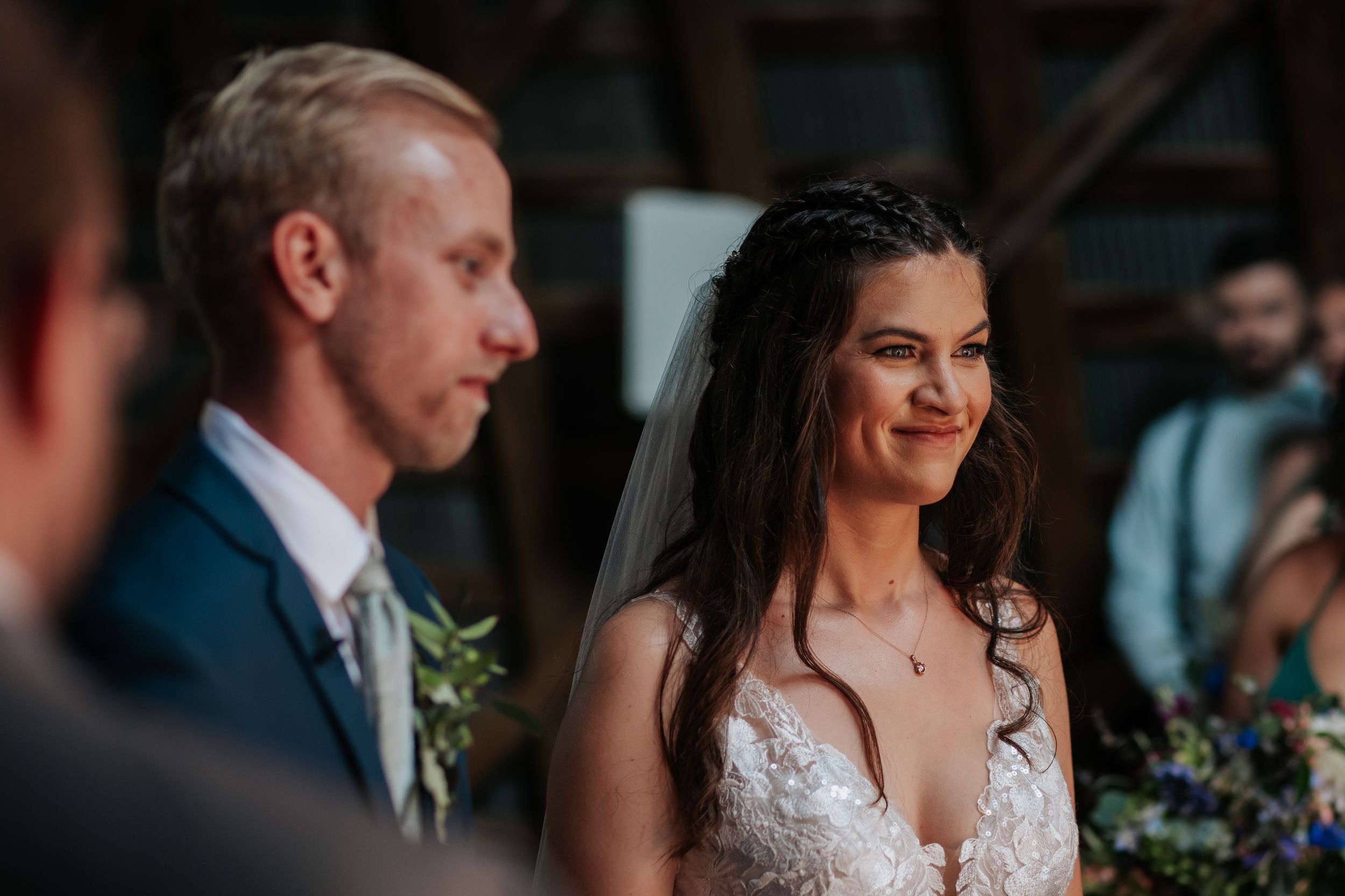 Emotional wedding ceremony moment in natural light with bride in lace dress.