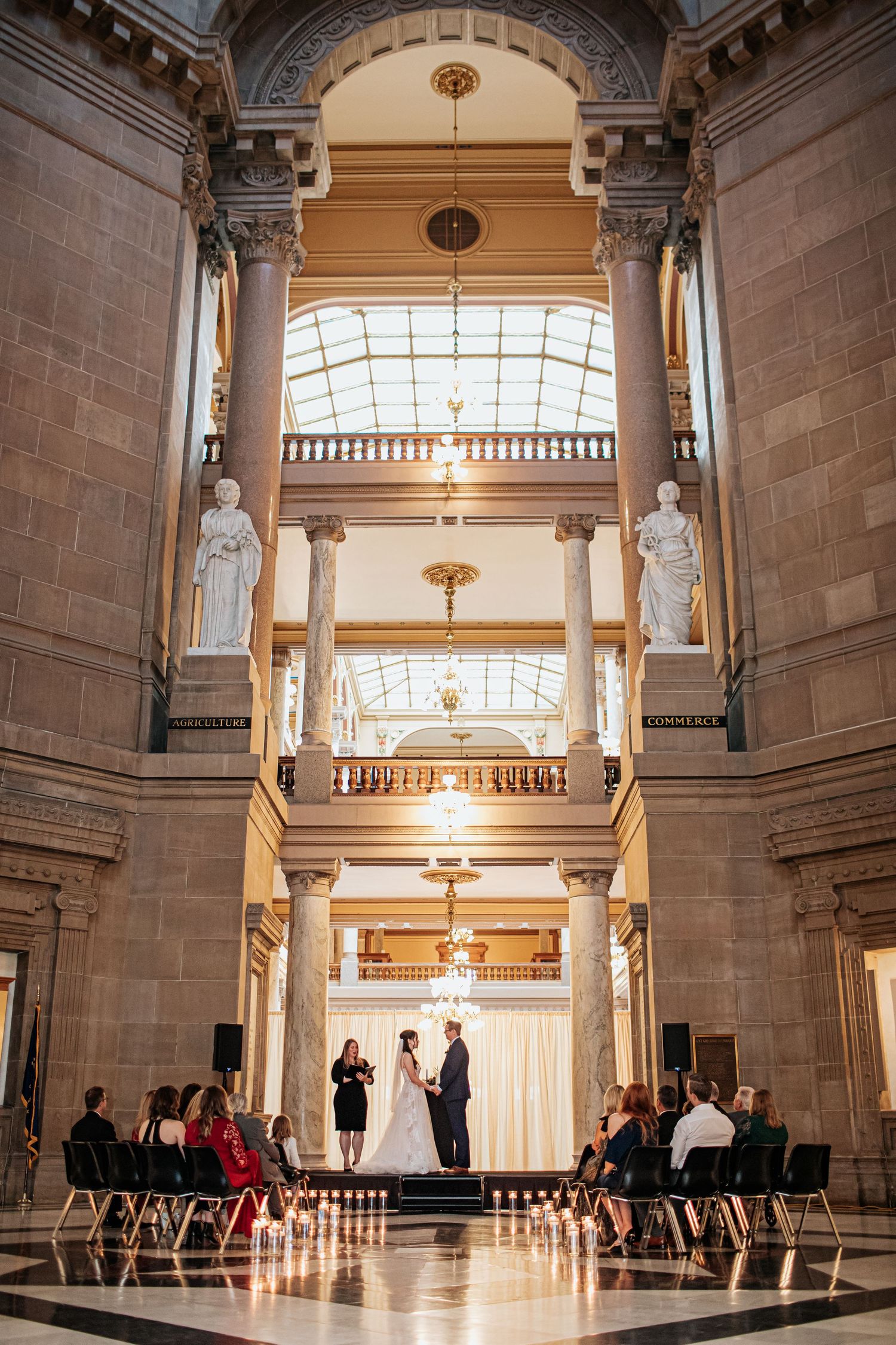 Wedding ceremony in a grand historic building with classical architecture and marble columns.