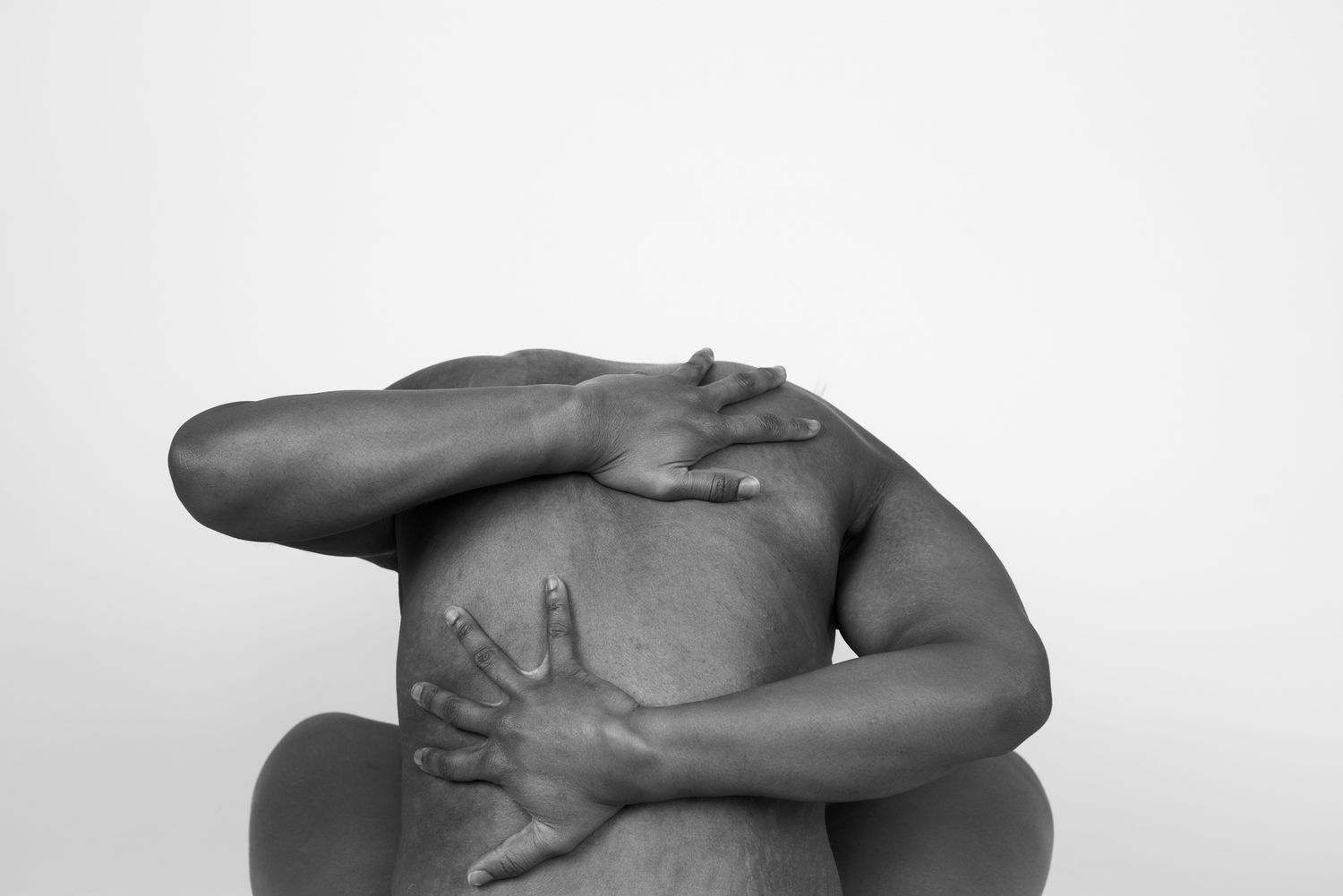 Black and white artistic study of curved human forms against white background.