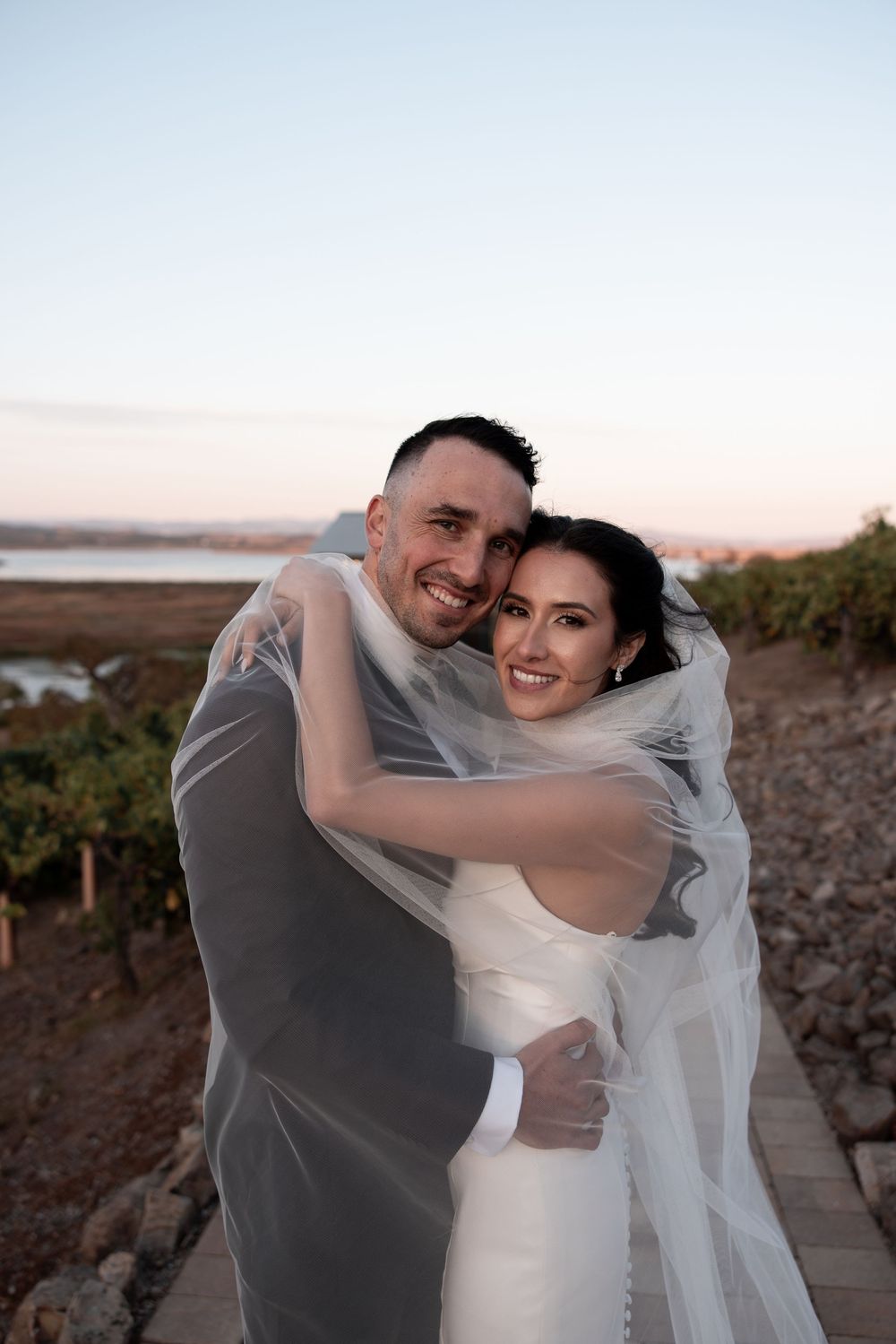 A romantic wedding photo series showing a couple embracing in warm sunset light on a scenic overlook.