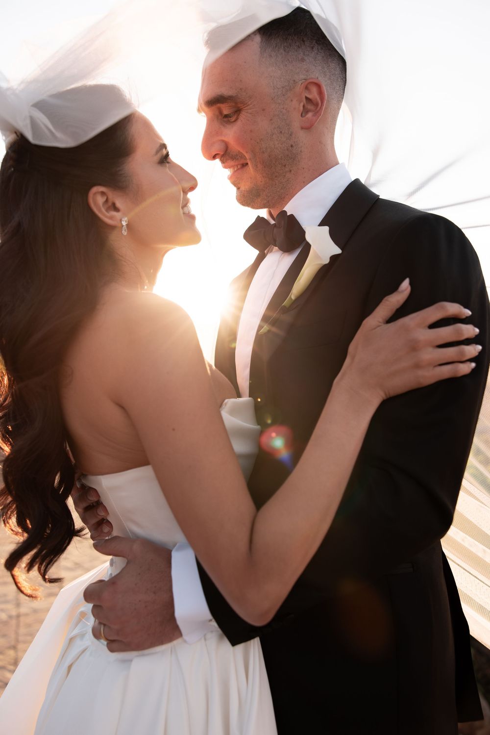 A romantic wedding photo series showing intimate moments between a bride and groom backlit by golden sunlight.