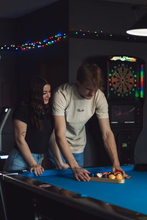 Couple setting up billiard balls on a blue pool table in a Yelm WA dive bar during photoshoot with local pierce county photographer