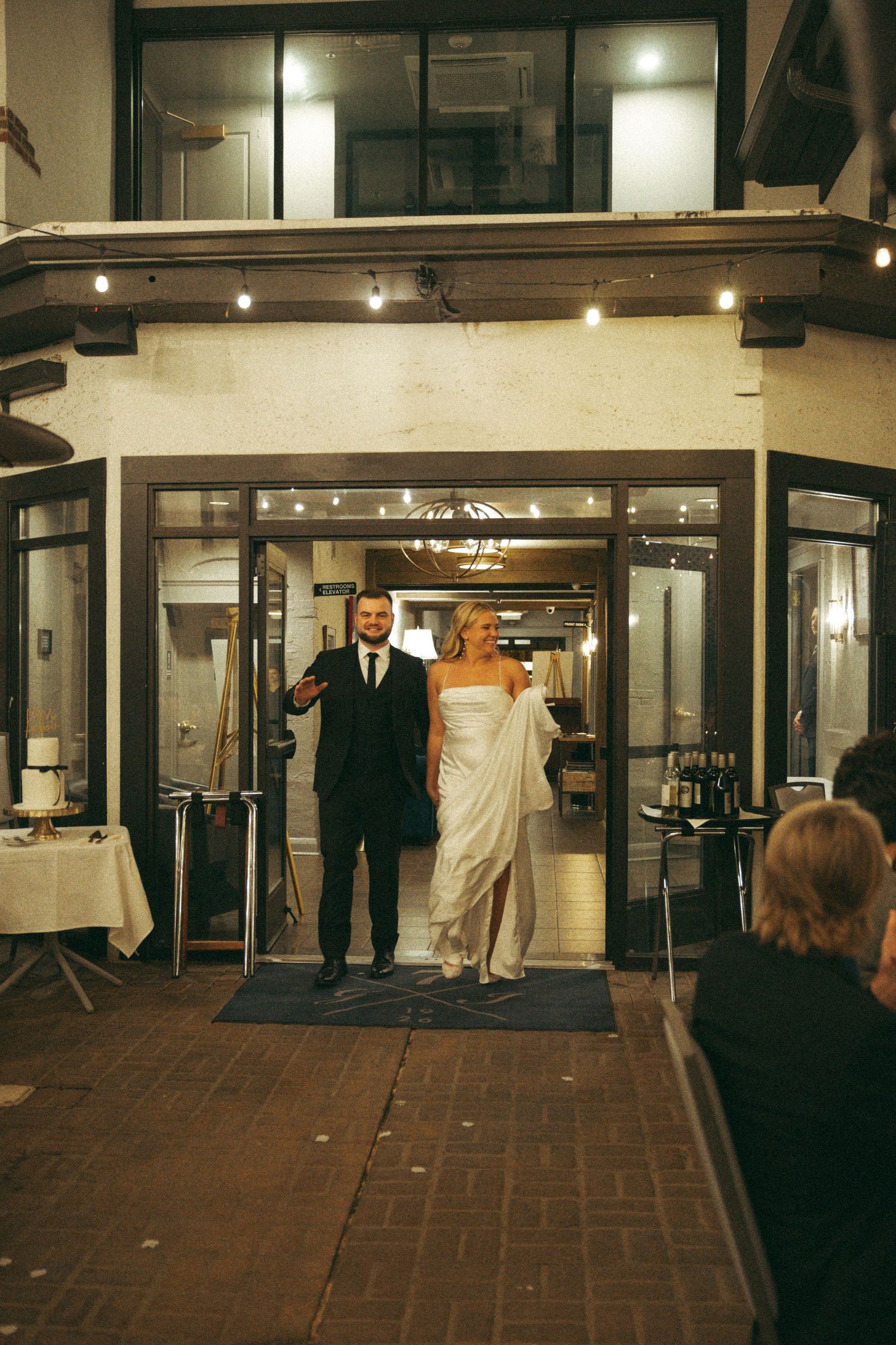 A sequence of photos showing people entering and exiting through glass doors at a building entrance at night.