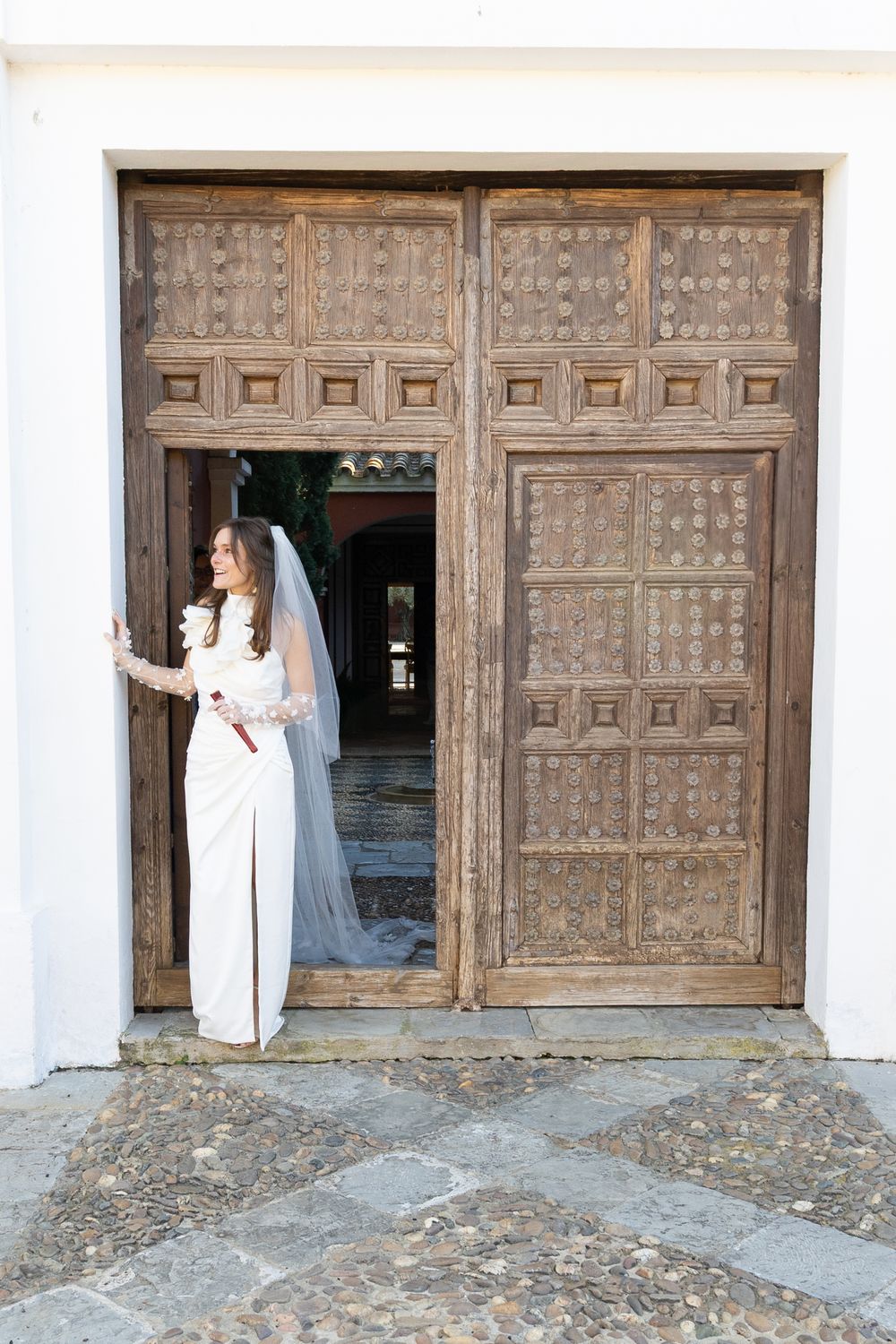 A progression of shots showing someone in white approaching ornate wooden doors at a historic building entrance.