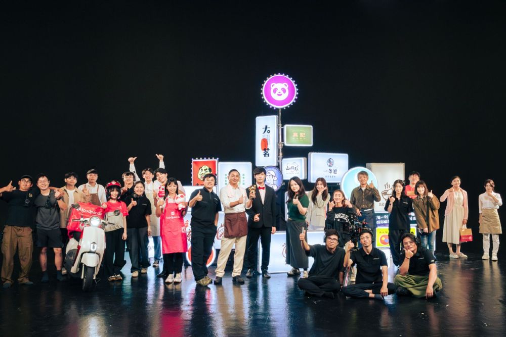 People stand in line on a dark stage during what appears to be a performance or presentation event.