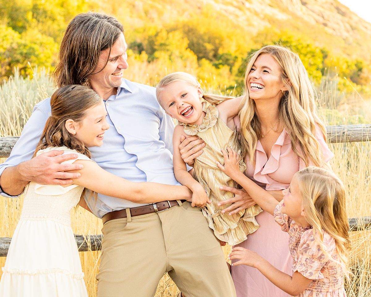 A joyful group portrait taken in a field of tall golden grass during sunset at Hidden Valley Park.