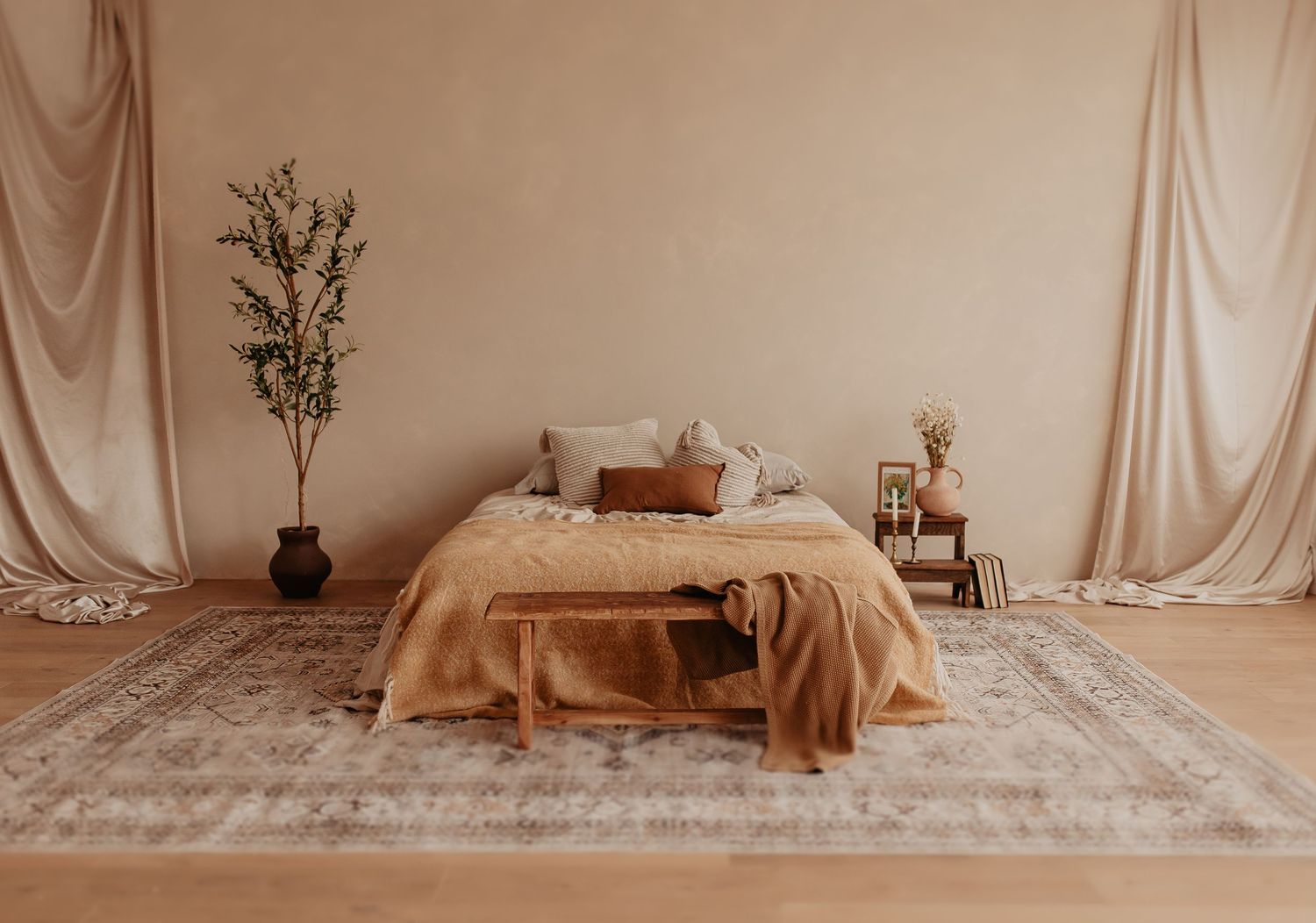 Minimalist studio setup with neutral drapes and dried floral arrangements.