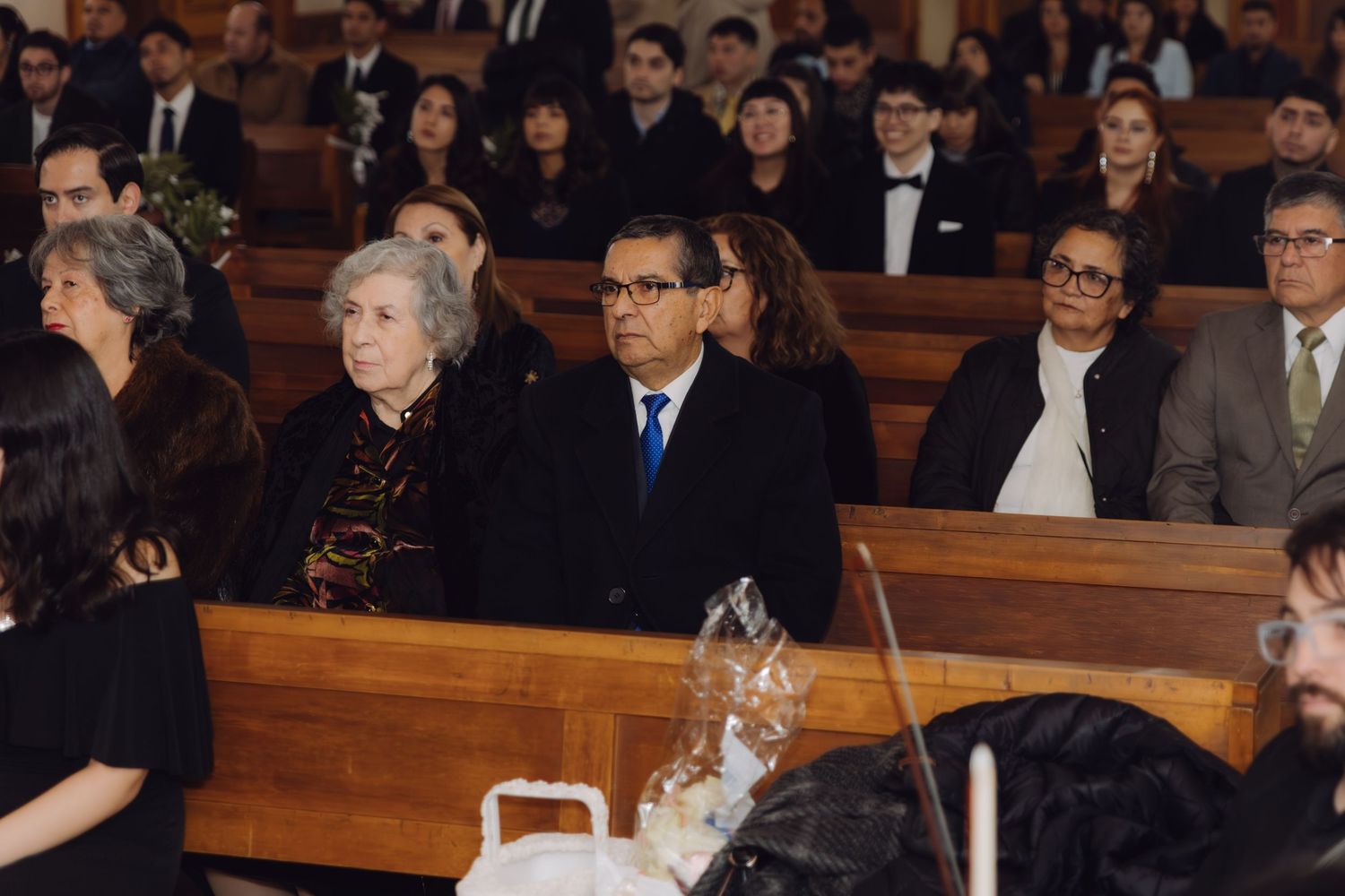 Wedding guests seated in church pews during a formal wedding ceremony.
