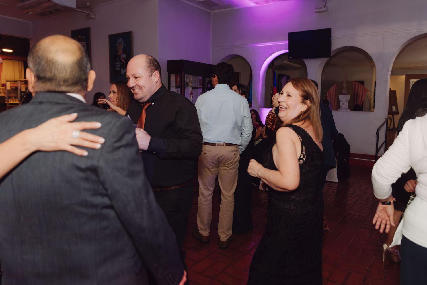 Wedding guests dancing together on the dance floor at a formal reception.