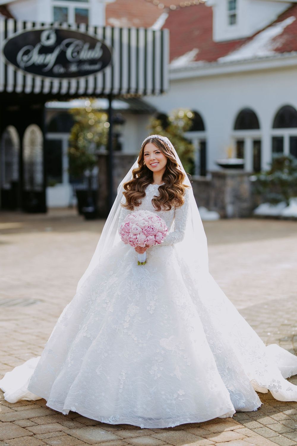 An elegant bridal portrait series showcasing a flowing white ball gown with lace details on stone pavement.
