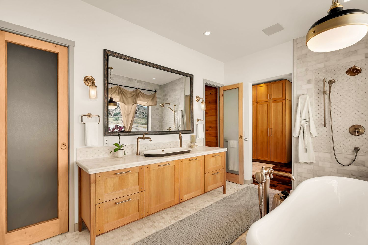 Modern bathroom interior with wooden vanity, white walls, and sleek fixtures showcases a clean minimalist design.