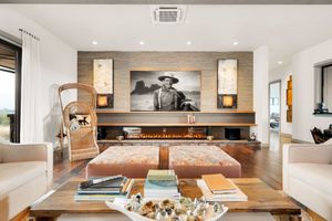 Expansive modern living area featuring white walls, built-in shelving, and natural wood accents.