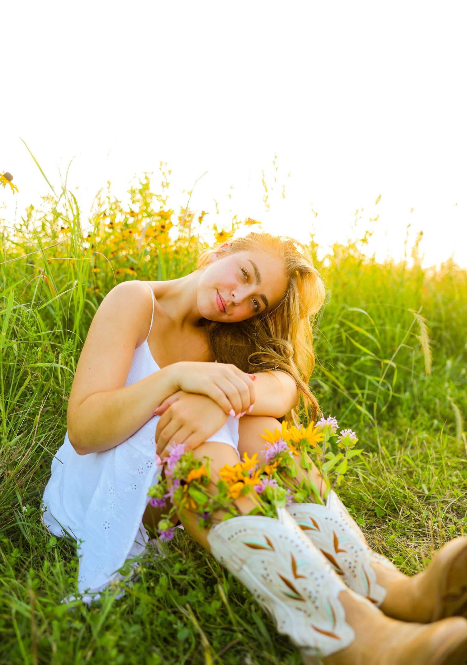 Senior photography in flower field with cowboy boots and flowers sticking out of them in lake elmo, MN.