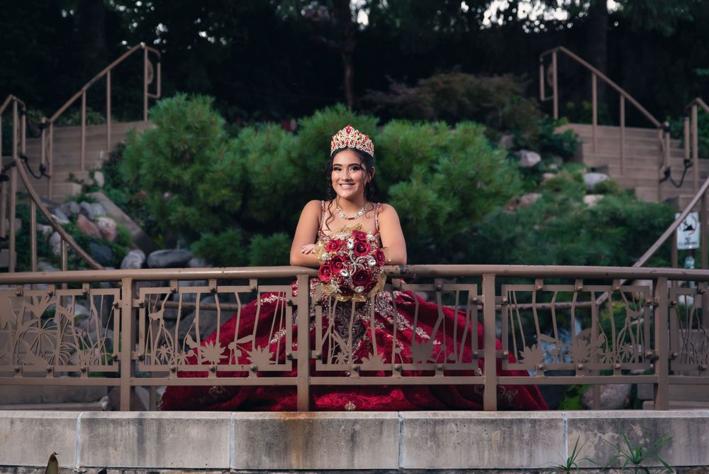 Red formal dress captured in dramatic poses along an outdoor railing.