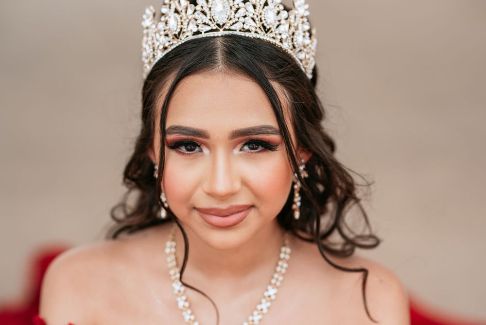 An elegant crown and jewelry set sparkles against a neutral studio backdrop.