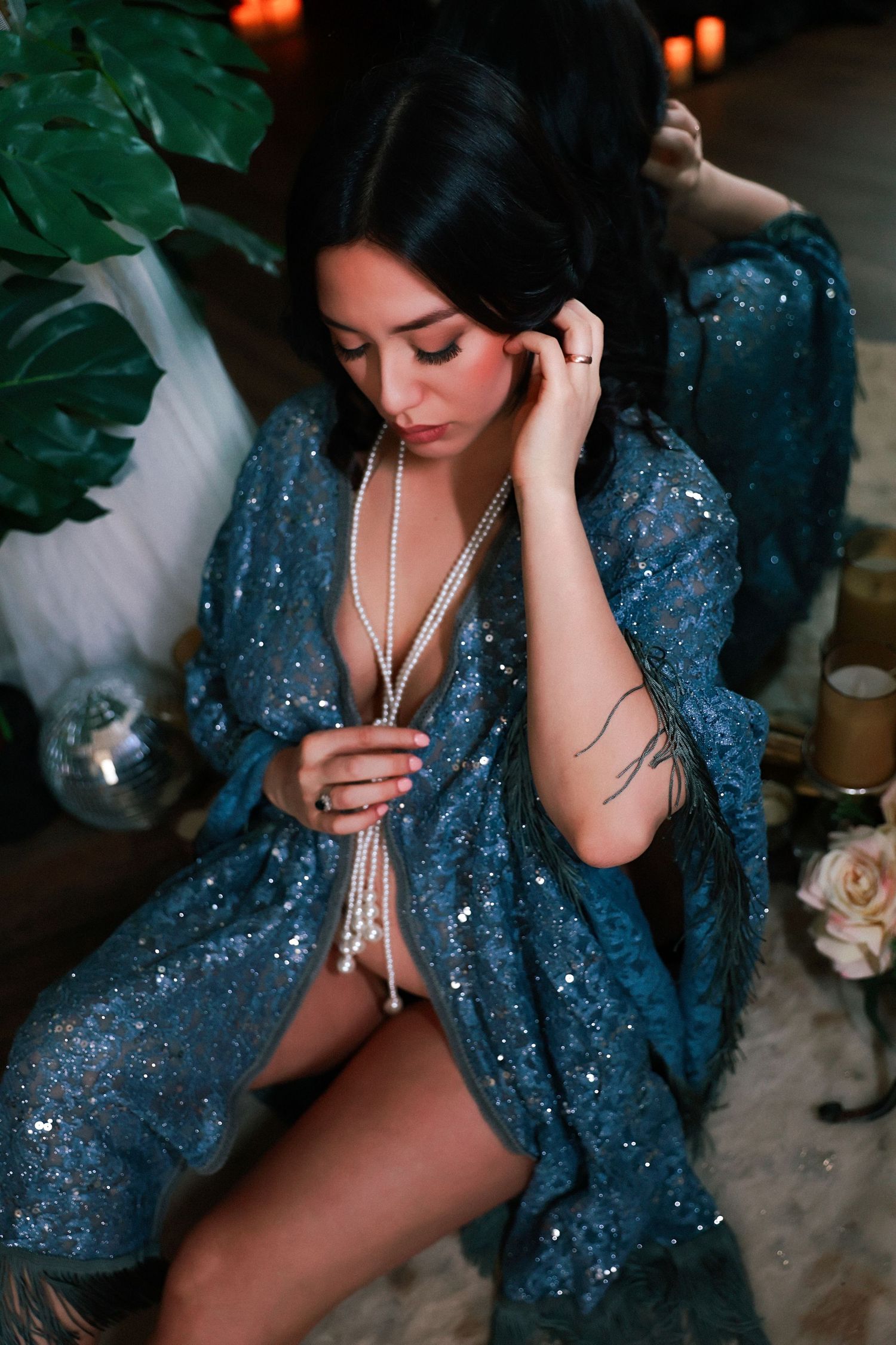 A figure in a sparkly blue robe poses sensually in an artistic boudoir photoshoot series.