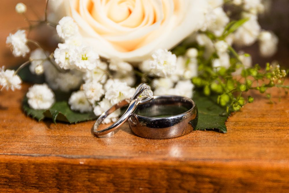 Delicate peach roses and white baby's breath flowers arranged on a rustic wooden surface create a romantic display.