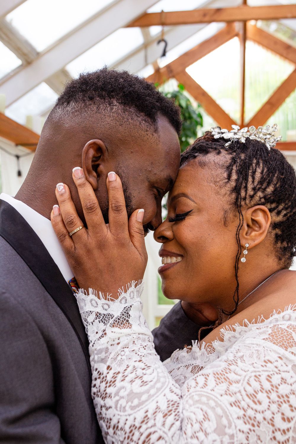 A tender moment between newlyweds sharing an intimate embrace, with the bride wearing delicate white lace.