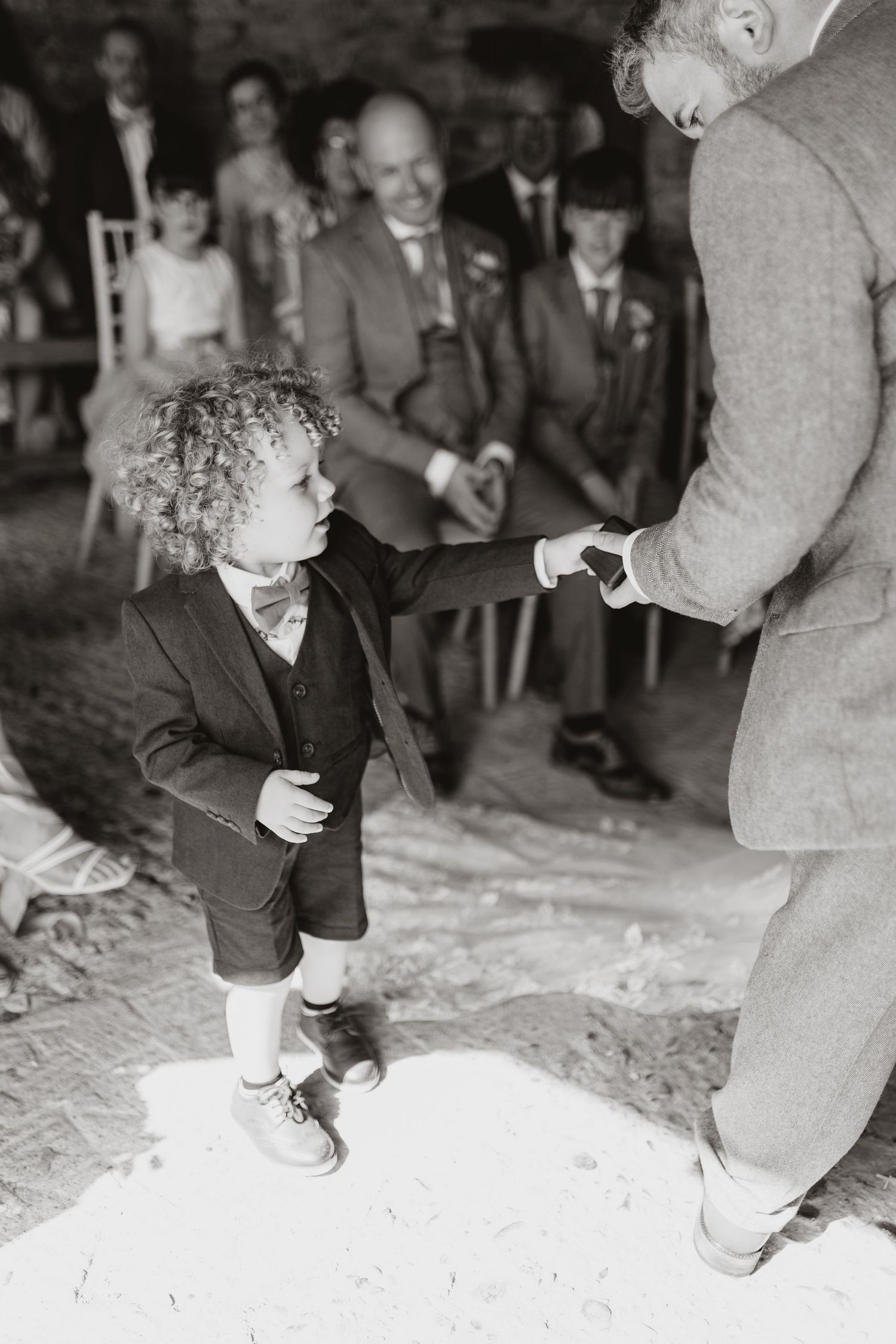 Page boy handing rings to groom at wedding at Lyde Court, Hereford.
