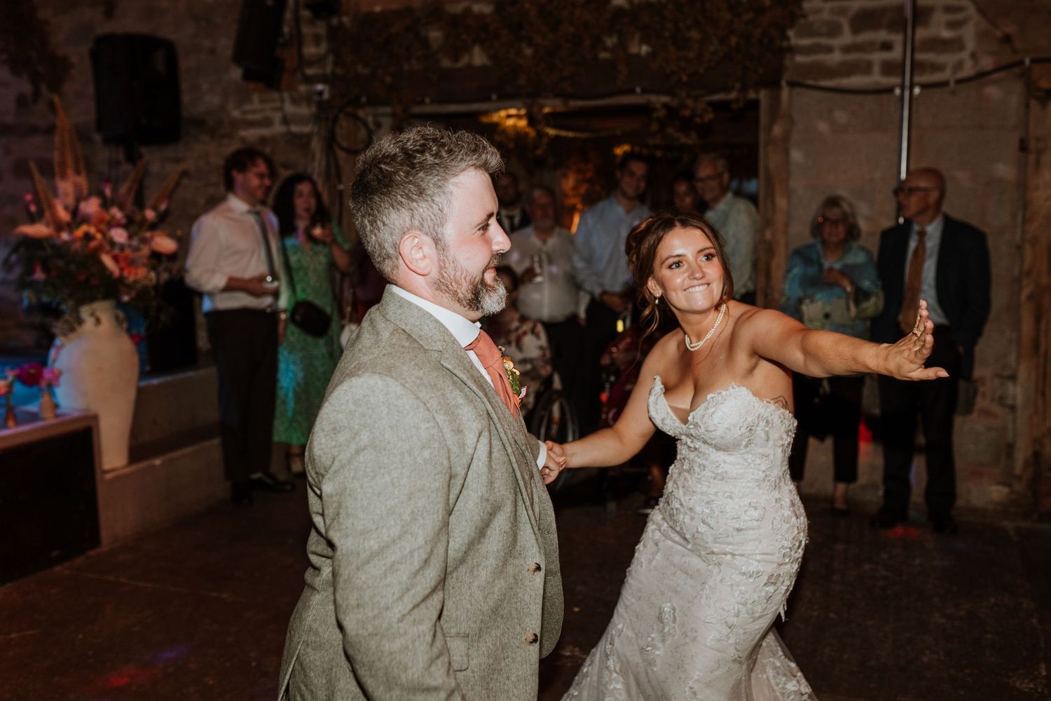 Couples dance together at an outdoor evening wedding reception under white bunting and string lights.