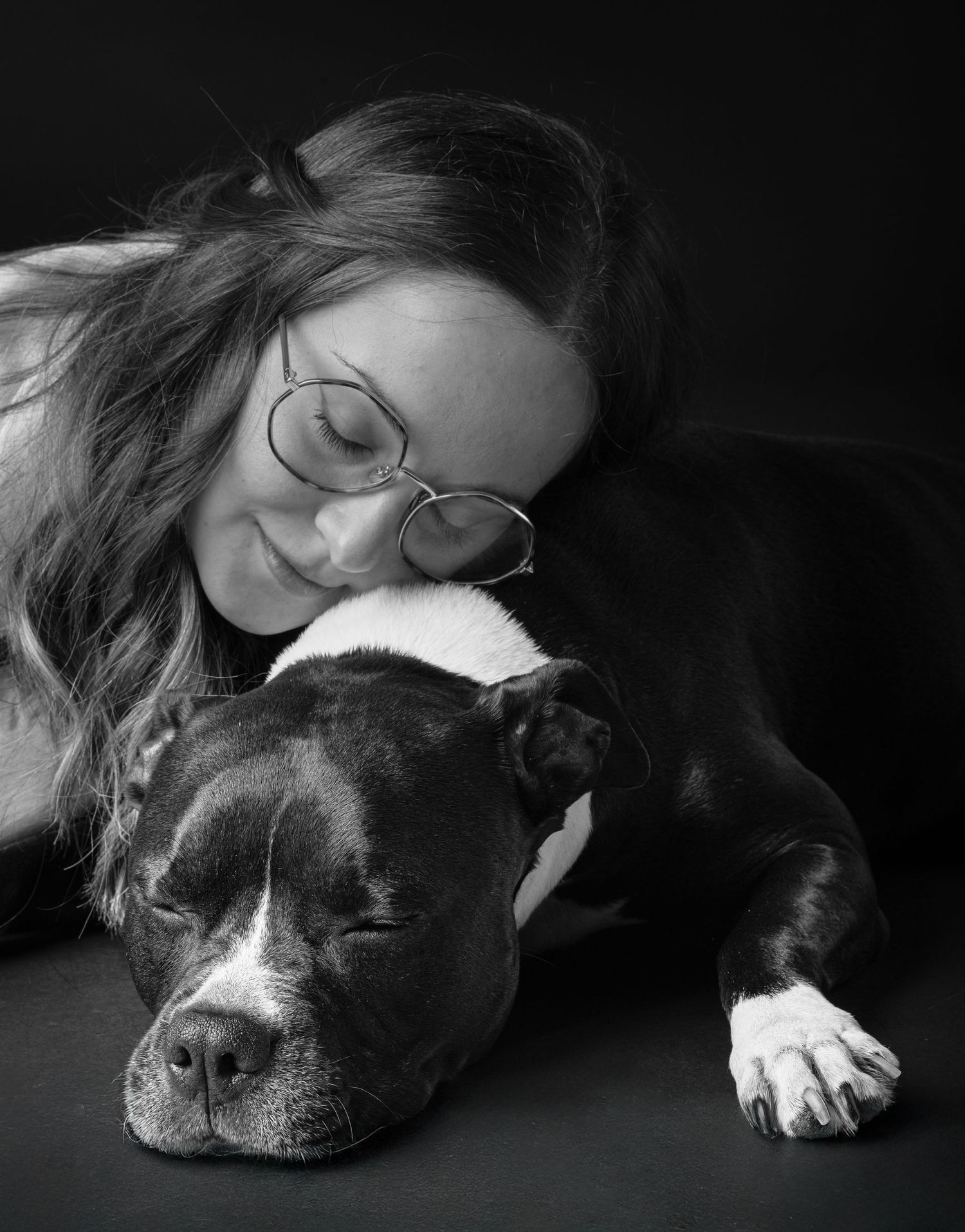 A series of black and white photographs showing a sleeping dog in different positions with a dark background.