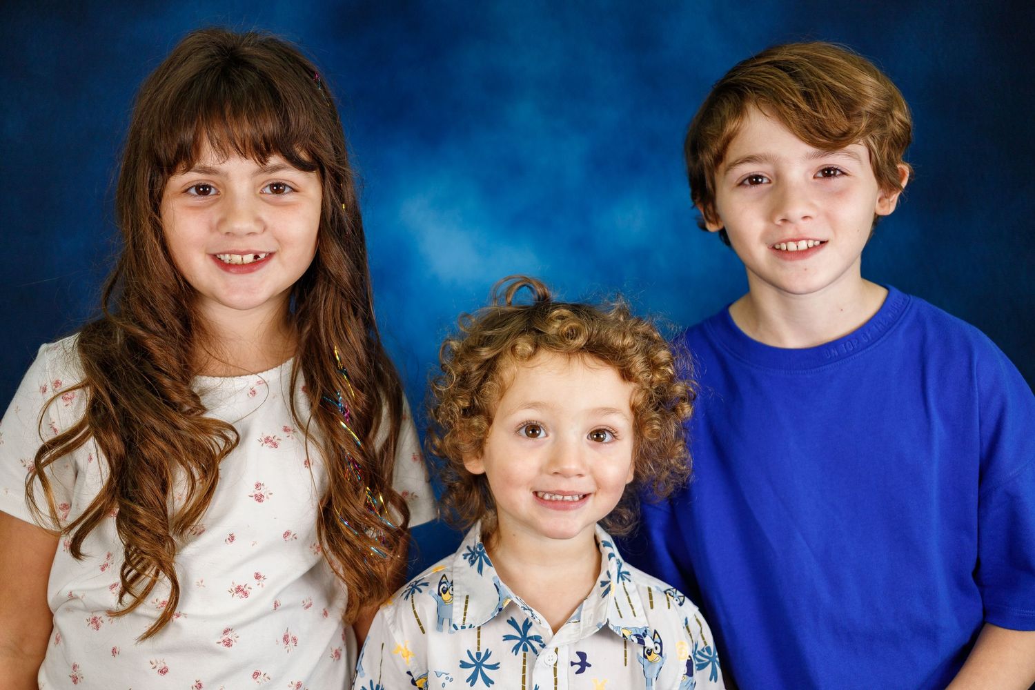 A series of four photos showing a child in a brown and white plaid shirt posing against a dark brown backdrop.