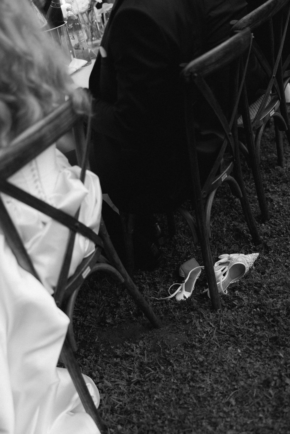 Black and white photo showing the edge of a dance floor with formal attire visible during an evening event.