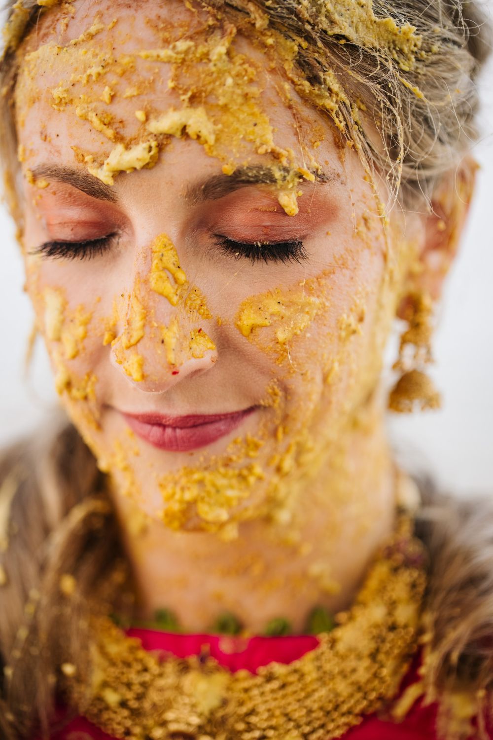 Close-up beauty shot showing golden turmeric powder applied to skin in a luxurious spa treatment ritual.