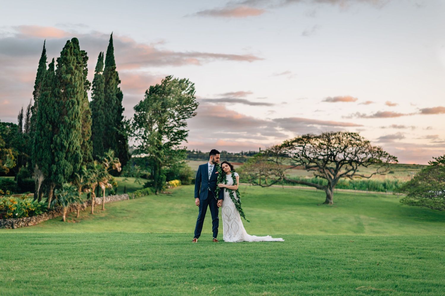 Sunset wedding portrait session on a sweeping green lawn with mountain views.