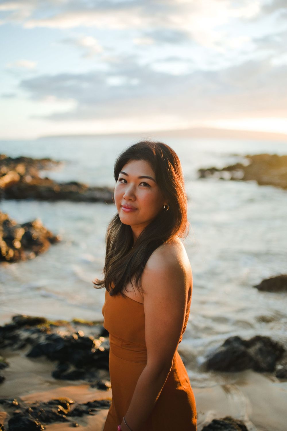 A series of sunset portraits at a rocky beach with warm golden lighting and ocean waves in the background.
