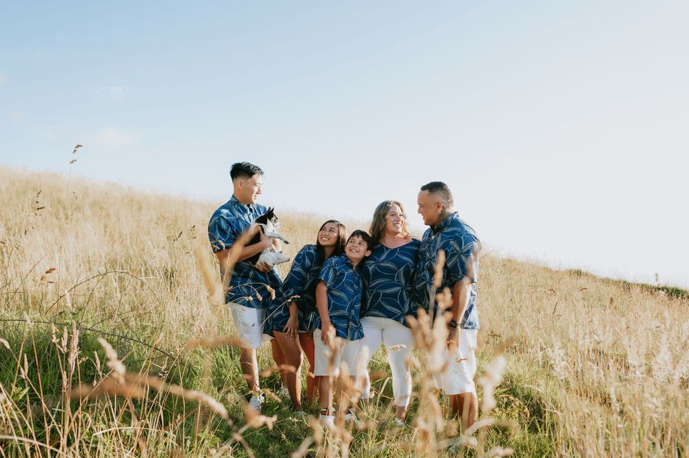 A group walks together through a golden hillside field on a sunny afternoon.
